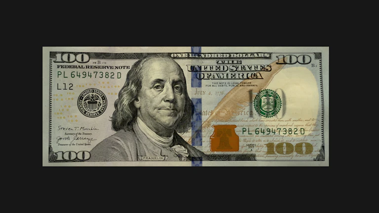 계산기와 달러 지폐가 놓여 있는 모습