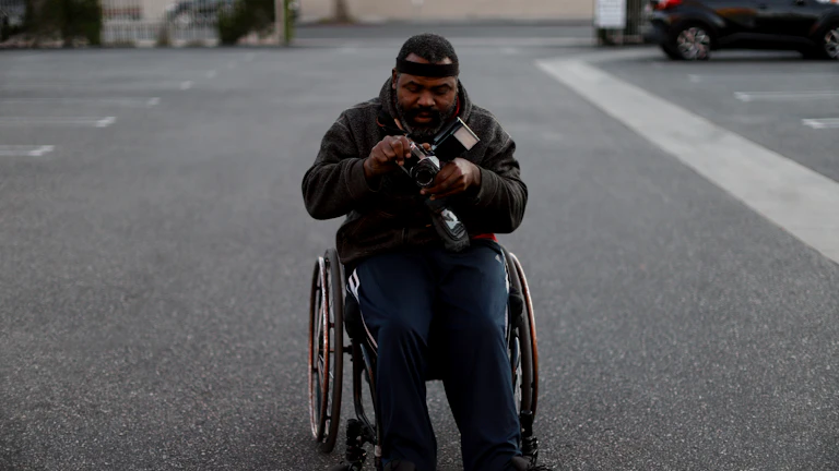 휠체어를 탄 장애인이 자동차에 앉아 있는 모습