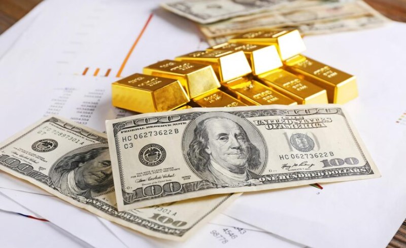 황금 골드바와 미국 달러 지폐가 테이블 위에 놓여 있는 모습