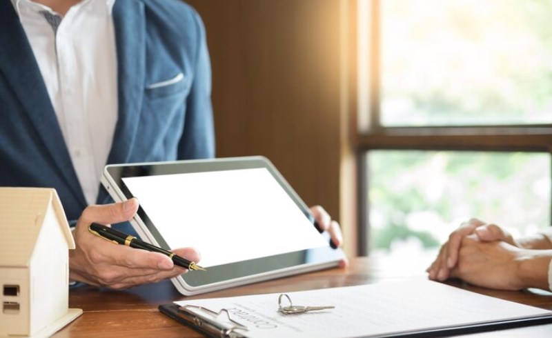 태블릿으로 부동산 계약서에 서명하는 행복한 커플