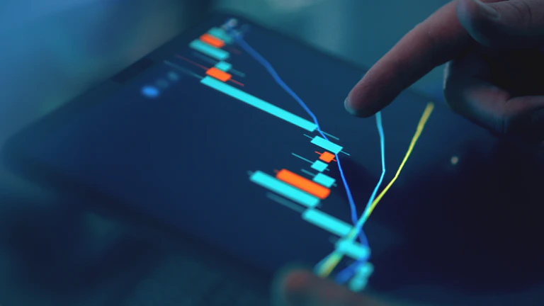 컴퓨터 화면으로 주식 차트를 보는 투자자