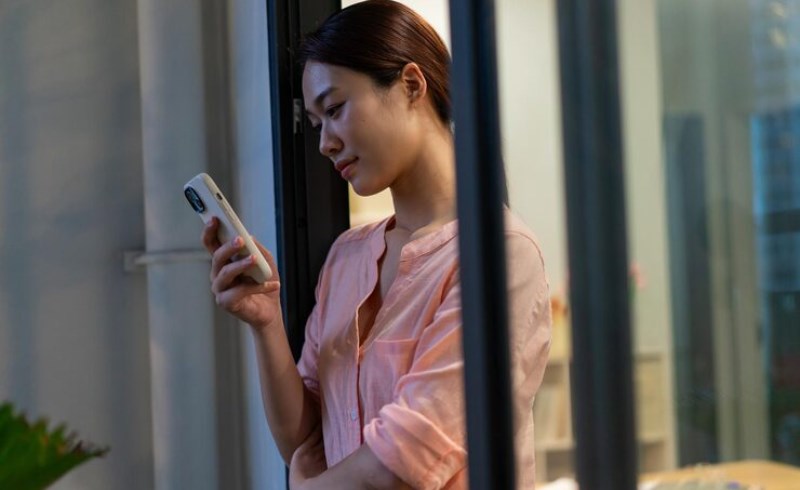 스마트폰으로 부동산 등기부등본과 보안 정보를 확인하는 사람