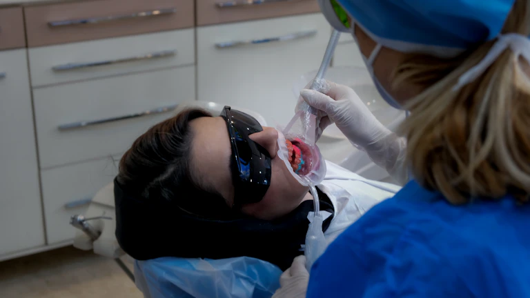 치과 의사가 거울로 환자의 치아를 검진하는 모습